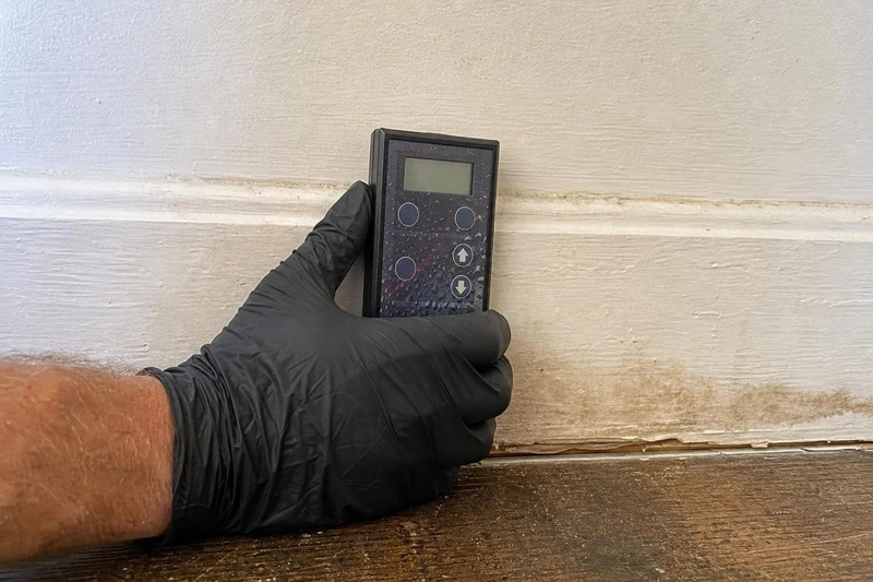 Water restoration technician running extraction equipment across a wet living room floor in a Frisco Texas home